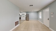 Located at 460 Hale Ave in Brooksville, FL, this one-bedroom, one-bathroom unit offers a practical and well-designed single-floor layout. The interior is finished with soft blue-gray walls and crisp white trim throughout, creating a clean, cohesive aesthetic. Light tile flooring spans the main living areas, contributing to a bright and airy feel.

The open-concept layout connects the living room, dining area, and kitchen in one continuous space. Large windows allow natural light to fill the room, offering views of the surrounding greenery. The kitchen is equipped with white shaker-style cabinetry, light countertops, and a full suite of stainless steel appliances, including a refrigerator, range, and over-the-range microwave, all set against light wood-look flooring.

The bedroom is a comfortable, well-proportioned space featuring tile flooring, a ceiling fan with light fixture, a window with outdoor views, and two sliding-door closets that provide generous storage capacity. The bathroom continues the clean design with a white vanity, tiled tub surround, light wood-look flooring, and access to an additional closet. This unit combines functional design with a neutral, move-in-ready finish throughout.