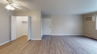 This single-floor unit offers a functional and well-appointed layout designed for comfortable everyday living. The galley-style kitchen is efficiently organized, featuring granite-look countertops, white shaker-style cabinetry, a black electric range, and a dishwasher — all set above durable light wood-look vinyl flooring that extends into the main living areas. The open living and dining area is bright and versatile, with warm wood-tone vinyl flooring, neutral grey walls, and a ceiling fan that adds both style and practicality. A pass-through layout connects the space seamlessly, enhancing the sense of openness. The bedroom is a comfortable retreat, finished with plush carpet, a window that invites natural light and views of surrounding greenery, and a baseboard heating unit. A bifold-door closet provides convenient built-in storage. The full bathroom is clean and straightforward, featuring a white tub-shower surround, a toilet, a vanity with storage, and matching wood-look flooring that ties the space together. Throughout the unit, consistent neutral tones, white trim, and updated finishes create a cohesive, move-in-ready aesthetic that is both practical and inviting.