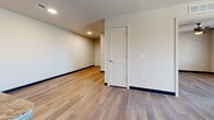 Located at 6055 S 11th Ave in Phoenix, Arizona, this single-story, three-bedroom, two-bathroom home offers a well-designed layout with a consistent, modern aesthetic throughout. Light wood-style flooring flows seamlessly across every room, complemented by crisp white walls, dark baseboards, and clean panel-style interior doors that create a cohesive, contemporary look.

The kitchen is a standout feature, offering rich dark wood cabinetry with sleek hardware, granite-style countertops, a center island with a sink, and black appliances including a refrigerator, electric range, microwave, and dishwasher. Recessed lighting illuminates the space efficiently.

Each of the three bedrooms is bright and functional, featuring ceiling fans with light fixtures and windows with horizontal blinds that invite natural light while maintaining privacy. The primary bedroom provides a comfortable footprint, while the additional bedrooms offer versatile space for various needs.

The two bathrooms continue the home's clean design language, featuring wood-style flooring, dark-toned vanities with light countertops, and tiled shower areas — one with a tub/shower combo and one with a walk-in shower.

The open living area connects naturally to the kitchen, enhancing the overall flow of the home. With its consistent finishes and practical layout, this Phoenix residence delivers a comfortable and functional living environment.