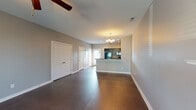 Located in Nashville, TN, this two-story home on Lausanne Drive is designed with a practical and functional layout across both floors. The main level features rich, dark hardwood flooring throughout the open living and dining areas, which flow naturally toward a galley-style kitchen. The kitchen is equipped with dark espresso cabinetry, dark granite-style countertops, a double stainless steel sink, recessed lighting, and black appliances including a refrigerator and dishwasher. A breakfast bar peninsula connects the kitchen to the main living space, which is illuminated by a classic chandelier. Ceiling fans are present throughout the home, contributing to year-round comfort.

The upper level transitions to plush carpeting and houses the bedrooms, each finished with neutral gray walls, ceiling fans, and blinds-covered windows that allow natural light to filter in. One bedroom features a notably spacious walk-in closet outfitted with wire shelving and its own window. The bathrooms are finished with dark vanity cabinetry, light countertops, and large mirrors. One bathroom includes a tub-shower combination with white surround. Throughout, the home maintains a clean, neutral palette that lends itself to a move-in-ready aesthetic.