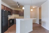 Located in Columbus, Georgia, this single-floor residence offers a thoughtfully designed layout with a cohesive blend of comfort and functionality. The open living area greets you with rich hardwood-style flooring, crown molding, and neutral warm-toned walls that create a bright and welcoming ambiance. A ceiling fan with pendant lighting accents the space, which flows seamlessly into a well-defined dining area and kitchen.

The kitchen is a standout feature, showcasing rich dark-stained cabinetry, light countertops, a subway tile backsplash, and a full suite of black appliances including a refrigerator, range, microwave, and dishwasher. A breakfast bar with pendant lighting connects the kitchen to the living space, enhancing both utility and openness.

The bedrooms are finished with plush carpeting and ceiling fans, providing a comfortable retreat. Each room benefits from natural light through window treatments, with views of the surrounding neighborhood. A generously sized walk-in closet with wire shelving offers practical storage. The bathroom is well-appointed with tile flooring, a tub-shower combination with tiled surround, and a dark-stained vanity with a large mirror. The home's layout and finishes make it a practical and comfortable living space.