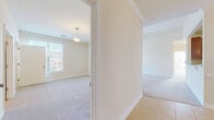 This single-story home offers a thoughtfully arranged layout encompassing four bedrooms, two bathrooms, a combined living, dining, and kitchen area, a dedicated laundry room, and two closets. The interior is finished in warm neutral tones throughout, creating a cohesive and inviting ambiance.

The kitchen features rich cherry-toned cabinetry with ample upper and lower storage, granite-look countertops, and black appliances including a refrigerator, microwave, and range. A breakfast bar with pendant lighting connects the kitchen to the carpeted living area, while the adjacent dining space is accented by a classic chandelier and tile flooring that extends through the kitchen.

The bedrooms are carpeted and filled with natural light from single windows, each maintaining a clean, understated aesthetic with neutral walls and pendant or ceiling-mounted light fixtures. The primary bedroom offers a comfortable footprint with closet access.

The bathrooms are finished with tile flooring, granite-topped wood vanities, and mirrors. The dedicated laundry room includes washer/dryer hookups and overhead wire shelving. Crown molding is present in key areas, adding a refined touch to the overall design.