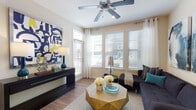 This single-story, one-bedroom, one-bathroom residence is thoughtfully designed to maximize both comfort and functionality. The living area serves as the heart of the unit, featuring warm wood-style flooring, a ceiling fan, and multiple large windows fitted with horizontal blinds and sheer curtains that invite generous natural light. A glass-paneled door provides access to an outdoor area, further enhancing the sense of openness.

The kitchen is well-equipped with granite countertops, dark cabinetry, black appliances including a gas range and refrigerator, a built-in microwave, and a dishwasher. Pendant lighting and a galley-style layout make the space efficient and practical for everyday cooking.

The bedroom is comfortably sized, offering wood-style flooring, a ceiling fan, and large windows that allow ample daylight. The room provides a calm and restful atmosphere.

The full bathroom features tile flooring, a granite-topped vanity with dark wood cabinetry, a large mirror with overhead lighting, and a soaking tub with shower combination. The clean, neutral palette throughout the bathroom creates a polished, functional space. Overall, the unit presents a cohesive, modern aesthetic with warm tones and quality finishes.