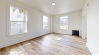 Located at 3333 W 4th St in the heart of Los Angeles, this well-appointed one-bedroom, one-bathroom unit offers a clean, modern aesthetic throughout. Light wood-tone flooring runs seamlessly across all rooms, creating a warm and cohesive feel. The layout flows logically from a connecting hallway into the main living areas.

The living room is bathed in natural light from large double-hung windows that frame lush greenery and palm tree views, giving the space an airy, inviting atmosphere. A classic cast-iron radiator adds a charming, functional accent.

The galley-style kitchen is thoughtfully designed with crisp white shaker cabinetry extending to the ceiling for ample storage, a white quartz countertop, an undermount sink with a modern faucet, and stainless steel appliances including a gas range and refrigerator. A window at the end of the kitchen brings in additional natural light.

The bedroom is a comfortable, well-proportioned retreat featuring two windows overlooking trees and neighboring architecture, a cast-iron radiator, and the same warm hardwood-style flooring found throughout.

The bathroom is finished in a clean, all-white palette with a soaking tub, overhead rain shower, a sleek vanity with quartz countertop, framed mirror, and a frosted privacy window for natural light.