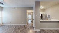 Located at 2003 Skyline Dr in McKinney, TX, this single-story 2-bedroom, 2-bathroom residence offers a clean, modern aesthetic throughout. Wood-style plank flooring runs continuously across the living areas, hallway, and bedrooms, creating a cohesive and low-maintenance foundation. The living room serves as the heart of the home, featuring a tile-surround fireplace, a ceiling fan with light fixture, and a large window with patio door access that fills the space with natural light. Adjacent to the living area, the kitchen is outfitted with white shaker-style cabinetry, a subway tile backsplash, white quartz countertops, stainless steel appliances including a refrigerator, range, and microwave, and a peninsula with an undermount sink — ideal for casual dining or meal prep. A central hallway connects the two bedrooms and bathrooms, maintaining an efficient and private layout. Both bedrooms include ceiling fans, windows with blinds, and neutral walls. The bathrooms are appointed with gray vanity cabinetry, gold hardware accents, white quartz countertops, and tub/shower combinations. Textured ceilings and consistent neutral-toned walls throughout contribute to the home's bright, welcoming ambiance.