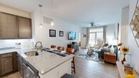This 950 square foot single-story residence in Virginia Beach offers a thoughtful layout with 3 bedrooms and 3 bathrooms. The heart of the home is an open-concept living area, seamlessly connecting the kitchen, dining, and living spaces. The kitchen boasts modern amenities, including stainless steel appliances, granite countertops, and ample cabinetry in a warm taupe finish. Pendant lighting adds a touch of elegance.

The living room features a ceiling fan, large windows allowing natural light, and sliding glass doors leading to an outdoor space. Neutral tones dominate the interior, with pops of blue in the furnishings echoing the coastal location. The primary bedroom, measuring 140 square feet, provides a cozy retreat.

Throughout the home, attention to detail is evident in the carefully chosen decor, from abstract wall art to functional storage solutions in the closets. The bathrooms showcase contemporary fixtures and finishes, with one featuring a glass-enclosed shower. Hardwood-style flooring in the main living areas and plush carpeting in the bedrooms add warmth and comfort.

This efficiently designed home balances style and functionality, making it an ideal space for modern coastal living in Virginia Beach.