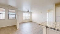 This contemporary apartment showcases a thoughtfully designed open floor plan that maximizes space and light. The interior is characterized by its bright, airy ambiance, enhanced by multiple windows that allow natural light to flood the rooms. Throughout the apartment, wood-style flooring adds warmth and elegance to the space.

The heart of the home is a modern kitchen, featuring sleek white cabinetry, granite countertops, and a suite of stainless steel appliances. A central island with a granite top provides additional workspace and casual dining options. The living area seamlessly connects to the kitchen, creating an ideal space for entertaining or relaxing.

Bedrooms are generously sized, with large windows and ceiling fans for comfort. The bathroom boasts a clean, modern design with a white vanity, granite countertop, and a shower-tub combination with stylish black fixtures.

Storage solutions are integrated throughout, including a dedicated closet space with wire shelving. The apartment also features recessed lighting, central air conditioning, and blinds on all windows for privacy and light control. With its neutral color palette and contemporary finishes, this apartment offers a blank canvas for personalization while providing all the amenities of modern living.