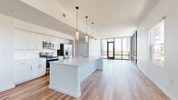 Located in the heart of Phoenix's vibrant Roosevelt Row arts district, this contemporary 2-bedroom, 3-bathroom residence offers a sleek, modern living experience across a single thoughtfully designed floor. The open-concept living, dining, and kitchen area serves as the centerpiece of the home, bathed in natural light from dramatic floor-to-ceiling windows that frame sweeping views of the downtown Phoenix skyline, palm trees, and surrounding cityscape. A private patio extends this connection to the outdoors seamlessly. The chef's kitchen is outfitted with stainless steel appliances, a large waterfall-edge island with a double sink, white quartz countertops, and modern cabinetry with pendant lighting overhead. Warm wood-tone flooring flows throughout the entire residence, complementing the clean, white walls and contemporary finishes. The generously sized primary bedroom offers ample natural light and is accompanied by a spa-inspired en-suite bathroom featuring a dual-sink vanity, marble-tiled walk-in shower, and crisp white cabinetry. A second well-appointed bedroom and additional full bathrooms with marble-surround tubs ensure comfort for residents and guests alike. Multiple closets and a dedicated laundry area add practical convenience to this polished urban retreat.
