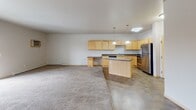 Located at 4822 47th St S in Fargo, North Dakota, this single-floor unit offers a practical and well-appointed layout designed for comfortable everyday living. The open-concept living and dining area is generously sized, finished with plush carpeting, and brightened by a sliding glass door that leads to a private balcony, allowing natural light to fill the space and providing outdoor views of the surrounding neighborhood.

The kitchen is a standout feature, equipped with light maple cabinetry offering ample storage, dark laminate countertops, and a full suite of stainless steel appliances including a refrigerator, electric range, built-in microwave, and dishwasher. A peninsula with pendant lighting above creates a natural divide between the kitchen and living area, adding both function and visual interest. Tile flooring runs throughout the kitchen for easy maintenance.

The bedrooms are carpeted and well-sized, each benefiting from natural light through windows. The bathroom is finished with tile flooring, a single vanity with a large mirror, wall-mounted cabinetry, and a full tub-shower combination. Baseboard heating is present throughout the unit, and a wall-mounted air conditioning unit serves the main living area. The overall palette is neutral and clean, offering a move-in ready canvas.