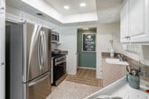 Located at 23411 Summerfield in Aliso Viejo, CA, this well-appointed one-bedroom, two-bathroom single-story home offers a thoughtfully designed layout filled with natural light. Light wood flooring flows throughout, complementing the neutral palette and creating a warm, cohesive atmosphere.

The open-concept living, dining, and kitchen area serves as the heart of the home. The living room features large windows with blinds that bathe the space in abundant natural light, while a sliding glass door leads to a private patio, seamlessly blending indoor and outdoor living. The dining area, accented by a ceiling fan fixture, sits adjacent to the kitchen, which boasts white cabinetry, granite countertops, stainless steel appliances including a French door refrigerator and gas range, and a breakfast bar with seating.

The spacious primary bedroom offers a serene retreat with soft, neutral tones, a dedicated closet, and direct access to one of the two full bathrooms, which features a tub-shower combo and white vanity cabinetry. A second full bathroom serves guests. A dedicated laundry area with an in-unit washer adds everyday convenience. This home combines functional design with a relaxed coastal-inspired aesthetic in a desirable Southern California community.