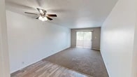 Located at 909 Tijeras Ave NW in Albuquerque, New Mexico, this one-bedroom, two-bathroom unit offers a well-organized single-floor layout designed for comfortable everyday living. The living room is a welcoming, open space featuring warm carpet flooring, a ceiling fan with light fixture, a textured ceiling, and a sliding glass door that opens to a private balcony, allowing natural light to fill the room. An accent wall with vertical paneling adds a subtle design element to the space. The galley-style kitchen is efficiently designed, featuring white cabinetry, a mosaic tile backsplash, wood-look flooring, a full suite of white appliances including a refrigerator and electric range, and ample counter space. The bedroom is generously proportioned with soft carpeting, a textured ceiling, a window with outdoor views, and a built-in closet for storage. Both bathrooms are clean and functional — one features a framed mirror, a mosaic tile backsplash at the vanity, and wood-look flooring, while the second includes a full tub-shower combination with smooth surround walls. Throughout the unit, a neutral color palette and consistent finishes create a cohesive, move-in-ready atmosphere.