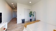 Located on the sixth floor at 1942 Fawcett Ave in downtown Tacoma, WA, this efficiently designed studio unit offers a thoughtful single-floor layout that maximizes every square foot. Light-toned hardwood-style flooring runs throughout, lending a clean, cohesive aesthetic to the entire space.

The galley-style kitchen is positioned along one wall and features dark wood cabinetry extending to the ceiling, stainless steel appliances including a refrigerator and microwave, and a compact sink — all designed to make the most of the available footprint.

The main living and sleeping area is bright and airy, anchored by a large picture window that floods the room with natural light and offers open views of the surrounding Tacoma cityscape and hillside. A sliding-door closet provides convenient built-in storage along one wall.

The unit includes two bathrooms, each finished with wood-toned vanity cabinetry, white countertops, and the same light hardwood-style flooring. One bathroom features an open shelving unit, adding both storage and a decorative touch.

Throughout the unit, the white walls and recessed lighting contribute to a clean, modern ambiance. The overall design is practical and contemporary, making this a well-appointed urban residence in the heart of Tacoma.