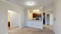 Located at 4110 Wake Hills Ln in Raleigh, NC, this single-story, 3-bedroom, 2-bathroom home offers a well-organized and functional layout. The open-concept living and kitchen area serves as the heart of the home, where plush wall-to-wall carpeting flows through the living space and crown molding adds a refined architectural touch. Large windows invite natural light and provide views to the exterior, enhancing the airy feel of the room.

The kitchen features rich dark-espresso cabinetry, granite-look countertops, a breakfast bar peninsula, and a full suite of black appliances including a refrigerator, range, and over-the-range microwave. Light tile flooring extends through the kitchen and both bathrooms, providing a clean contrast to the carpeted areas.

The generously sized primary bedroom includes a dedicated bathroom with a single vanity, granite-look countertop, built-in shelving, and tile flooring. The additional bedrooms are well-proportioned, each featuring natural light from windows and closets with built-in rod and shelf storage. The second full bathroom offers a tub/shower combination and a dark-wood vanity.

Additional highlights include a laundry room, utility room, and four closets throughout. The home's neutral palette and consistent finishes create a cohesive and move-in-ready environment.