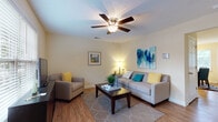 Located at 609 Easy St in Kannapolis, NC, this two-story home offers a well-organized layout designed for comfortable everyday living. The living room features warm hardwood-style flooring, a ceiling fan with light fixture, and a textured ceiling, creating an inviting and relaxed atmosphere with ample space for entertaining or unwinding. Adjacent to the living area, the dining space benefits from natural light streaming through slatted blinds, a stylish pendant chandelier overhead, and direct access to an exterior door — ideal for indoor-outdoor flow. The kitchen is equipped with warm oak cabinetry, granite-style countertops, and white appliances including a range, oven, and full-size refrigerator. The home includes multiple bedrooms, each finished with plush carpeting, ceiling fans, and large windows that allow generous natural light. The primary bedroom features a dark wood furniture aesthetic and a full-length window panel. Bathrooms are finished with tile flooring, wood vanity cabinetry, and a shower-tub combination. A dedicated laundry room houses a full-size washer and dryer with built-in wire shelving above — a practical and convenient amenity. Throughout, the home maintains a neutral, warm color palette that lends a cohesive and welcoming character across both floors.