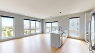 Located at 455 Snelling Ave N in Saint Paul, Minnesota, this contemporary residence offers four bedrooms and three bathrooms across a single thoughtfully designed floor. The open-concept living and kitchen area serves as the heart of the home, where light wood-tone flooring and a soft gray palette create a clean, modern aesthetic. Oversized windows flood the space with natural light and frame sweeping views of the surrounding cityscape, including glimpses of downtown Saint Paul.

The kitchen is equipped with stainless steel appliances—including a French door refrigerator, range, microwave, and dishwasher—complemented by a large center island with an integrated sink, white cabinetry, and subway tile backsplash accents. A sleek pendant light fixture anchors the island as a central gathering point.

The bedrooms feature plush carpeting, ceiling fans, and generous closet space, including walk-in and sliding-door closets with built-in shelving. The primary bedroom offers a comfortable footprint with ample storage. The three bathrooms are finished in a consistent modern style, featuring white vanities with drawer storage, matte black hardware accents, and tub-shower combinations. A dedicated entry area with built-in storage adds everyday convenience to this well-appointed Saint Paul residence.