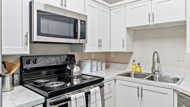 This brilliantly upgraded kitchen will serenade your senses. Capture the luminous allure as it dances off the white cabinets and glistening stainless-steel appliances. - Greystone Woods