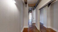 Located in the heart of downtown Houston at 909 Texas Ave, this 1-bedroom, 1-bathroom loft-style residence masterfully blends industrial character with modern updates. The space is defined by rich polished concrete floors, exposed structural beams, and visible ductwork that pay homage to the building's architectural heritage, while crisp white walls and contemporary finishes provide a clean, updated contrast.

The combined kitchen and dining area features stainless steel appliances, white subway tile backsplash, white upper cabinetry, gray lower cabinetry with sleek black hardware, and quartz countertops — all set atop warm natural hardwood floors that distinguish this zone from the rest of the unit. A dedicated pantry offers additional storage.

The hallway, lined with polished concrete flooring, connects the living areas to the private bedroom, which features exposed wooden beams overhead, a ceiling fan with light, and a spacious closet with wire shelving. The bathroom is well-appointed with large-format tile flooring, a glass-enclosed walk-in shower with white subway tile, mosaic tile flooring, and a gray vanity with a quartz countertop. A utility room conveniently houses a stacked washer and dryer. The entrance provides a welcoming transition into this distinctive urban retreat.