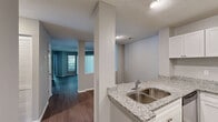 Located at 1301 Buckingham Station Dr in Midlothian, VA, this well-appointed 3-bedroom, 2-bathroom single-floor residence offers a comfortable and functional layout. The open living room is bathed in natural light courtesy of large sliding glass doors that lead to a private balcony overlooking mature, lush greenery — creating a serene indoor-outdoor connection. Durable hardwood-style flooring flows consistently throughout the home, lending a cohesive, modern aesthetic.

The kitchen is thoughtfully designed with granite countertops, white shaker-style cabinetry, stainless steel appliances including a range, microwave, dishwasher, and refrigerator, plus a peninsula with an undermount sink — ideal for both cooking and casual dining.

The three bedrooms are generously proportioned with neutral gray walls and large windows that invite abundant natural light and exterior views. One bedroom features built-in shelving, adding practical storage. The primary bedroom is notably spacious, offering ample room for comfortable furnishings.

Both bathrooms are finished with granite-topped white vanities and full tub/shower combinations with tiled surrounds. Three closets provide excellent storage throughout. The overall ambiance is clean, bright, and move-in ready.