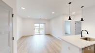 Located at 100 Mia Rose Way in Dardenne Prairie, Missouri, this well-designed one-bedroom, one-bathroom unit offers a thoughtfully organized layout across a single floor. Light-toned hardwood-style flooring flows consistently throughout, creating a bright, cohesive feel enhanced by crisp white walls and recessed lighting.

The open-concept kitchen and living area serves as the heart of the unit. The kitchen is outfitted with gray shaker-style cabinetry, a subway tile backsplash, stainless steel appliances — including a refrigerator, range, and built-in microwave — and a peninsula with a white countertop and pendant lighting, ideal for casual dining or food prep.

The living area connects seamlessly to a private balcony through a sliding glass door, allowing natural light to pour in and offering outdoor views of the surrounding area. A ceiling fan adds comfort to this space.

The bedroom is a comfortable size, featuring dual windows with blinds that bring in additional natural light, along with a ceiling fan overhead. A dedicated walk-in closet provides generous storage with multi-level wire shelving and hanging rods.

The bathroom is finished with gray vanity cabinetry, a backlit mirror, white countertops, and a glass-enclosed walk-in shower adorned with large-format marble-style tile — a refined touch that elevates the overall aesthetic of this modern unit.