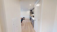 Located at 2024 Jane St in Pittsburgh's South Side neighborhood, this one-bedroom, one-bathroom unit offers a thoughtfully designed layout across a single floor. Light hardwood flooring runs throughout, lending warmth and continuity to the space.

The open living area flows directly into the kitchen, which is outfitted with contemporary gray wood-toned cabinetry extending to the ceiling for ample storage. Stainless steel appliances — including a full-size refrigerator, electric range, microwave, and dishwasher — are complemented by a clean white quartz countertop and a subway tile backsplash. Recessed lighting illuminates the space efficiently.

The bedroom is a comfortable, well-proportioned room featuring light-filled windows with roller shades that frame views of the surrounding Pittsburgh neighborhood. A wall-mounted HVAC unit ensures year-round climate control. A standout feature is the in-unit stacked washer and dryer, tucked neatly into a dedicated closet space within the bedroom — a practical convenience rarely found at this scale.

The bathroom is finished in a clean, modern aesthetic, with a frameless glass shower door, white tile surround, and sleek matte black hardware and fixtures throughout, creating a polished, cohesive look. The overall design of the unit prioritizes function and clean contemporary style.