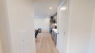 Located at 2024 Jane St in Pittsburgh's South Side neighborhood, this one-bedroom, one-bathroom unit offers a thoughtfully designed layout across a single floor. Light hardwood flooring runs throughout, lending warmth and continuity to the space.

The open living area flows directly into the kitchen, which is outfitted with contemporary gray wood-toned cabinetry extending to the ceiling for ample storage. Stainless steel appliances — including a full-size refrigerator, electric range, microwave, and dishwasher — are complemented by a clean white quartz countertop and a subway tile backsplash. Recessed lighting illuminates the space efficiently.

The bedroom is a comfortable, well-proportioned room featuring light-filled windows with roller shades that frame views of the surrounding Pittsburgh neighborhood. A wall-mounted HVAC unit ensures year-round climate control. A standout feature is the in-unit stacked washer and dryer, tucked neatly into a dedicated closet space within the bedroom — a practical convenience rarely found at this scale.

The bathroom is finished in a clean, modern aesthetic, with a frameless glass shower door, white tile surround, and sleek matte black hardware and fixtures throughout, creating a polished, cohesive look. The overall design of the unit prioritizes function and clean contemporary style.