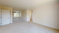 Located at 2619 Hydraulic Rd in Charlottesville, VA, this 2-bedroom, 2-bathroom single-floor residence offers a thoughtfully organized layout across a comfortable footprint. The living room features soft carpeting, crown molding, and a ceiling fan, with natural light filtering in through a window that offers outdoor views. It flows naturally into a dedicated dining area, creating an open, connected feel. The kitchen is well-appointed with warm wood cabinetry, tile backsplash, granite-style countertops, and black appliances including a gas range, over-the-range microwave, and refrigerator. A utility area conveniently houses a stacked washer and dryer alongside kitchen access, adding practical functionality. Both bedrooms are carpeted and bright, each with ceiling fans and windows that bring in natural light. The primary bedroom includes closet access, while the second bedroom features a sliding double-door closet. Three closets throughout the unit provide generous storage. Both bathrooms are finished with tiled shower-tub combinations and warm-toned flooring. Neutral, light wall tones throughout lend the space a clean, welcoming ambiance suited for comfortable everyday living.