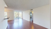 Located in the desirable Brentwood neighborhood of Los Angeles, this well-appointed 2-bedroom, 2-bathroom residence offers a thoughtfully designed layout across a single floor. Rich hardwood flooring runs throughout the main living areas and bedrooms, adding warmth and continuity to the space.

The open-concept living and dining area is bathed in natural light, courtesy of a full wall of floor-to-ceiling sliding glass doors that lead to a private balcony overlooking lush tree canopy views. The kitchen is a functional standout, featuring sleek gray cabinetry, dark granite countertops, stainless steel appliances—including a refrigerator, range, dishwasher, and microwave—and an in-unit washer. A peninsula counter provides additional prep space and connects the kitchen to the living area.

Both bedrooms offer hardwood flooring, white walls, and ample closet space with mirrored sliding doors. The unit includes four closets in total, providing generous storage throughout. The two bathrooms are finished with granite-topped vanities, gray tile flooring, and shower-tub combinations, delivering a clean and modern aesthetic.

A hallway connects the private quarters to the main living spaces, completing a practical and comfortable floor plan ideal for everyday living in one of Los Angeles's most sought-after westside neighborhoods.