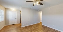 Located at 1400 Fifth Ave N in Naples, Florida, this single-floor, 2-bedroom, 1-bathroom home offers a practical and well-organized layout. Warm wood-look flooring flows consistently throughout the space, complementing the neutral, light-toned walls that create a clean and cohesive aesthetic.

The living room serves as the central gathering area, featuring a ceiling fan with light fixture and an open sightline toward the kitchen and hallway. The kitchen is efficiently designed with warm wood cabinetry, granite-style countertops, stainless steel appliances including a range and microwave, and a stainless sink — offering solid functionality in a compact footprint.

Both bedrooms are comfortably sized, each equipped with ceiling fans and windows fitted with horizontal blinds that allow for natural light and outdoor views of the surrounding greenery. The primary bedroom includes a built-in closet with bi-fold doors for organized storage. The home also benefits from three closets in total, providing generous storage throughout.

The bathroom features a wood-toned vanity with a granite-style countertop, a large mirror, and textured wall detailing. A hallway connects the main living areas to the bedrooms and bathroom, contributing to a straightforward and accessible floor plan. This home presents a well-maintained, move-in-ready option in a convenient Naples location.