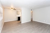 Located at 108 Vaquero Ln in El Paso, Texas, this single-floor residence offers a thoughtfully updated interior with consistent, modern finishes throughout. Wood-look plank flooring runs across the entire space, providing a clean and cohesive aesthetic from room to room.

The open living area welcomes natural light through a large front-facing window with blinds, and features a ceiling fan with light fixture overhead. A textured ceiling adds character to the space, while neutral wall tones create a calm, versatile backdrop. A partial dividing wall separates the living area from the kitchen, maintaining an open feel while defining each zone.

The galley-style kitchen is well-appointed with gray cabinetry, white quartz-style countertops, and a bold white subway tile backsplash with dark grout. Black appliances — including a refrigerator, electric range, dishwasher, and range hood — provide a striking contrast against the lighter finishes. A stainless steel sink and dedicated pantry closet complete the functional layout.

The bedroom is a comfortable, well-proportioned room with a ceiling fan, natural light from a window with blinds, and ample wall space. The bathroom features gray cabinetry with a large vanity mirror, white countertop, and a full tub-shower combination, all finished with the same wood-look flooring found throughout the home.