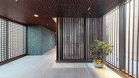 Located in Denver's Golden Triangle neighborhood, the Pool Lobby at 1140 Bannock St is a generously sized amenity space designed with a modern, sophisticated aesthetic. Floor-to-ceiling windows wrap the perimeter, flooding the interior with abundant natural light and framing panoramic views of the Denver skyline and the Rocky Mountains beyond.

The open-plan layout is divided into distinct zones, each thoughtfully appointed. A game area features a full-size billiards table and a shuffleboard table set atop large-format light stone tile flooring, creating a clean and airy atmosphere. Adjacent to this is a stylish bar and kitchen station with a long island countertop, bar seating, pendant lighting, and rich wood cabinetry equipped with professional appliances—ideal for entertaining.

A lounge and social area transitions the space into a warmer, more intimate setting, anchored by a linear gas fireplace set within a stone surround. A rich wood-paneled ceiling overhead adds warmth, while a flat-screen TV, built-in shelving, and curated artwork contribute to the refined atmosphere. Seating throughout includes contemporary sofas, lounge chairs, and café-style tables arranged atop a vivid blue area rug.

Additional window-side café seating areas invite relaxation with unobstructed city views, rounding out this well-equipped, design-forward communal space.