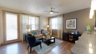 This single-floor residence offers a thoughtfully designed layout that balances style and functionality throughout. The living area serves as the heart of the home, featuring warm hardwood-style flooring, a ceiling fan, and multiple windows dressed with bold geometric-patterned curtains that invite an abundance of natural light. A textured ceiling adds character, while the open layout provides a comfortable and welcoming atmosphere.

The kitchen is a standout feature, equipped with dark espresso cabinetry, granite countertops, a mosaic tile backsplash, and a full suite of stainless steel appliances, including a range, microwave, and refrigerator. A breakfast bar with pendant lighting creates a casual dining space that connects seamlessly to the main living area.

The bedrooms are carpeted for comfort, each offering ceiling fans, natural light from well-positioned windows, and ample space for rest and relaxation. The bathroom is finished with dark cabinetry, granite countertops, tile flooring, and a tub-shower combination. A dedicated in-unit laundry area with a full-size washer and dryer adds everyday convenience, completing this efficiently designed and move-in ready residence.