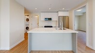 This contemporary apartment, located at 2453 Renfrew St in Vancouver, offers a well-designed living space of 77 square meters. The single-floor layout comprises three bedrooms, including a primary bedroom of 13 square meters, and two bathrooms. The open-concept design creates a seamless flow between living areas, enhancing the sense of space and light.

The kitchen is a highlight, featuring sleek white cabinetry, stainless steel appliances, and a large central island with a sink, providing both functionality and a social focal point. The inclusion of in-unit laundry adds convenience to daily living.

Throughout the apartment, hardwood floors lend warmth and elegance, while large windows allow natural light to flood the rooms. The bathrooms showcase modern fixtures, including a glass-enclosed shower in one and a spacious vanity in the other.

Built-in closets in the bedrooms offer ample storage space. The neutral color palette throughout creates a calm, contemporary ambiance, allowing for personalization. Recessed lighting in the kitchen and living areas adds to the modern aesthetic.

This well-appointed apartment combines style and practicality, offering a comfortable urban living experience in a desirable Vancouver location.