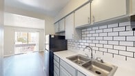 Located at 1500 Magruder St in El Paso, TX, this well-designed one-bedroom, two-bathroom unit offers a compact and functional layout across a single floor. Wood-look laminate flooring runs throughout, providing a clean and cohesive aesthetic in every room.

The kitchen is a standout feature, finished with gray cabinetry, white countertops, a classic white subway tile backsplash with contrasting dark grout, a double stainless steel sink, and a full suite of appliances including a gas range and refrigerator. Upper and lower cabinet storage ensures practical organization.

The living room is bright and open, with a textured ceiling, neutral walls, and a sliding glass door that leads to a private balcony offering views of the surrounding neighborhood. Natural light flows freely into the space through the large glass door.

The bedroom is a comfortable retreat with a ceiling fan with light fixture, wood-look flooring, and direct access to a dedicated closet. The neutral color palette keeps the room feeling airy and versatile.

Both bathrooms are functional and cleanly finished with wood-look flooring and light-toned walls. The unit also includes a dedicated closet for additional storage. Overall, this space offers a practical and well-appointed layout suited for efficient, comfortable living in El Paso.