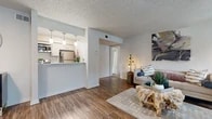 Located at 501 Green Oaks Ct in Arlington, TX, this one-bedroom unit offers a thoughtfully arranged single-floor layout that maximizes every square foot. The living room serves as the heart of the space, highlighted by a classic fireplace flanked by large windows that fill the room with natural light. Wood-style flooring flows throughout the main living areas, adding warmth and visual continuity, while a textured ceiling adds a distinctive architectural touch.

The kitchen features a galley-style design with stainless steel appliances, white cabinetry, and a clean countertop with an undermount sink. A peninsula with pendant lighting connects the kitchen to the dining and living areas, creating an open, functional flow ideal for everyday living and entertaining.

The dining area sits near the entryway, benefiting from additional window light and a welcoming atmosphere. A hallway leads to the bedroom, which is finished with plush carpet, a ceiling fan, and a window that brings in ample natural light. The bedroom offers a comfortable, private retreat with a dedicated closet for storage.

Overall, this unit presents a cohesive and practical living space with modern finishes, an efficient layout, and a bright, airy ambiance throughout.