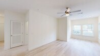 This well-appointed 2-bedroom, 2-bathroom home in Augusta, Georgia offers a clean, modern aesthetic throughout its single-story layout. Light hardwood flooring flows seamlessly across all living areas, creating a bright and cohesive atmosphere. The kitchen is a standout feature, showcasing rich dark-wood cabinetry, marble-style countertops, pendant lighting, and a breakfast bar peninsula — ideal for both cooking and casual dining. Black appliances, including a range, microwave, dishwasher, and refrigerator, complement the kitchen's bold contrast. The living areas are open and airy, benefiting from natural light streaming through windowed walls and ceiling fans that enhance comfort. The spacious primary bedroom offers ample room and a dedicated closet, while the second bedroom provides flexible space for guests or a home office. Both bathrooms are well-designed, with one featuring a walk-in shower, marble vanity countertop, and dark wood cabinetry with brushed nickel hardware. A dedicated laundry room with washer hookups and overhead shelving adds everyday convenience. The home's neutral color palette and consistent finishes throughout create a clean, move-in-ready environment.
