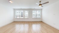 Located at 1100 Corinth St in Dallas, TX, this contemporary three-story townhome offers a well-designed layout spread across three distinct levels. The ground floor houses an attached garage equipped with an automatic opener and a water heater, along with a dedicated entrance that leads into the home via a staircase.

The main living level is bright and open, combining the living room, dining area, and kitchen into one cohesive, light-filled space. Light wood-look flooring runs throughout, complemented by crisp white walls and recessed lighting. The kitchen features a large center island with quartz countertops, sleek cabinetry, and elegant pendant lighting. Large windows invite abundant natural light and frame views of the surrounding neighborhood. A private balcony off this level provides an outdoor retreat with open-air views of the landscaped walkway and surroundings.

The upper floor is dedicated to the two bedrooms, each finished with plush carpeting, ceiling fans, and generous windows. The spacious primary bedroom includes a closet and its own bathroom. The additional bedroom is equally well-appointed with natural light and neighborhood views. Three full bathrooms throughout the home feature tiled tub-shower combinations. A laundry area and hallway complete the upper floor, making this townhome a functional and modern Dallas residence.