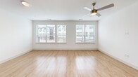 Located at 1100 Corinth St in Dallas, TX, this contemporary three-story townhome offers a well-designed layout spread across three distinct levels. The ground floor houses an attached garage equipped with an automatic opener and a water heater, along with a dedicated entrance that leads into the home via a staircase.

The main living level is bright and open, combining the living room, dining area, and kitchen into one cohesive, light-filled space. Light wood-look flooring runs throughout, complemented by crisp white walls and recessed lighting. The kitchen features a large center island with quartz countertops, sleek cabinetry, and elegant pendant lighting. Large windows invite abundant natural light and frame views of the surrounding neighborhood. A private balcony off this level provides an outdoor retreat with open-air views of the landscaped walkway and surroundings.

The upper floor is dedicated to the two bedrooms, each finished with plush carpeting, ceiling fans, and generous windows. The spacious primary bedroom includes a closet and its own bathroom. The additional bedroom is equally well-appointed with natural light and neighborhood views. Three full bathrooms throughout the home feature tiled tub-shower combinations. A laundry area and hallway complete the upper floor, making this townhome a functional and modern Dallas residence.