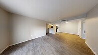 Located at 2701 N Decatur Blvd in Las Vegas, Nevada, this single-story, 2-bedroom, 2-bathroom residence offers a functional and well-appointed layout. The open-concept living and dining area is bright and spacious, featuring durable wood-style laminate flooring and neutral-toned walls that create a clean, modern aesthetic. A sliding glass door fitted with vertical blinds allows natural light to pour in and provides outdoor access. The galley-style kitchen is efficiently designed with white cabinetry, light stone-patterned countertops, a stainless steel sink, and black appliances including a gas range, refrigerator, and built-in microwave. The primary bedroom is generously sized, finished with plush carpeting, a ceiling fan, and direct access to an en-suite bathroom. The second bedroom also features carpet flooring and a window with blinds. Both bathrooms are finished with wood-style flooring, white vanities with light countertops, and tub-shower combinations. A dedicated in-unit laundry area houses a full-size washer and dryer. Two closets and a hallway complete the thoughtful floor plan, making this a practical and comfortable residence in Las Vegas.