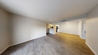 Located at 2701 N Decatur Blvd in Las Vegas, Nevada, this single-story, 2-bedroom, 2-bathroom residence offers a functional and well-appointed layout. The open-concept living and dining area is bright and spacious, featuring durable wood-style laminate flooring and neutral-toned walls that create a clean, modern aesthetic. A sliding glass door fitted with vertical blinds allows natural light to pour in and provides outdoor access. The galley-style kitchen is efficiently designed with white cabinetry, light stone-patterned countertops, a stainless steel sink, and black appliances including a gas range, refrigerator, and built-in microwave. The primary bedroom is generously sized, finished with plush carpeting, a ceiling fan, and direct access to an en-suite bathroom. The second bedroom also features carpet flooring and a window with blinds. Both bathrooms are finished with wood-style flooring, white vanities with light countertops, and tub-shower combinations. A dedicated in-unit laundry area houses a full-size washer and dryer. Two closets and a hallway complete the thoughtful floor plan, making this a practical and comfortable residence in Las Vegas.