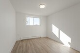 Located at 196 Sixth Avenue in Kitchener, Ontario, this one-bedroom, one-bathroom unit offers a thoughtfully laid-out single-floor plan with a clean, modern aesthetic. Light wood laminate flooring runs throughout the living areas, complementing the crisp white walls and trim that give the space a bright, airy feel.

The kitchen is a standout feature, outfitted with white shaker-style cabinetry, a classic white subway tile backsplash, dark countertops, and a full suite of stainless steel appliances including a refrigerator, electric range with over-the-range microwave, and dishwasher. A window above the counter allows natural light to fill the space. A peninsula with additional cabinetry provides extra storage and flows naturally toward the hallway entrance.

The living room is an open, sunlit area that connects seamlessly to the kitchen, offering a comfortable and flexible layout. The bedroom is a well-proportioned, private retreat bathed in natural light from a dedicated window, with a closet and baseboard heating. The bathroom features grey stone-look tile flooring, white subway tile surrounding the tub-shower combination, and a window for natural ventilation. A welcoming hallway with closet storage connects all rooms efficiently, completing this clean and functional home.