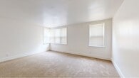 Located at 3201 Lancaster Avenue in Wilmington, Delaware, this single-floor home offers five bedrooms, one bathroom, a kitchen, and a connecting hallway within a compact and efficiently arranged floor plan. The bedrooms are carpeted throughout and feature crisp white walls with clean white baseboards. Several rooms are equipped with bay-style and standard windows fitted with blinds, allowing ample natural light to filter in and cast warm patterns across the floors. The spacious primary bedroom stands out for its generous proportions and multi-window configuration. Additional bedrooms are similarly bright, each with corner or bay windows that enhance the sense of openness. The hallway connects rooms through arched and paneled doorways, providing a cohesive flow throughout the unit. The kitchen is outfitted with warm oak cabinetry, a white electric range, a full-size refrigerator, a dishwasher, a single-basin sink, and a built-in countertop shelf — all set atop durable wood-look flooring. The bathroom includes a soaking tub, toilet, wood-vanity with sink, a wall mirror, and a window for natural ventilation. Overall, the home presents a clean, functional, and well-lit living environment suited for multi-occupant living.