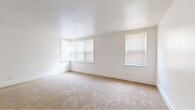 Located at 3201 Lancaster Avenue in Wilmington, Delaware, this single-floor home offers five bedrooms, one bathroom, a kitchen, and a connecting hallway within a compact and efficiently arranged floor plan. The bedrooms are carpeted throughout and feature crisp white walls with clean white baseboards. Several rooms are equipped with bay-style and standard windows fitted with blinds, allowing ample natural light to filter in and cast warm patterns across the floors. The spacious primary bedroom stands out for its generous proportions and multi-window configuration. Additional bedrooms are similarly bright, each with corner or bay windows that enhance the sense of openness. The hallway connects rooms through arched and paneled doorways, providing a cohesive flow throughout the unit. The kitchen is outfitted with warm oak cabinetry, a white electric range, a full-size refrigerator, a dishwasher, a single-basin sink, and a built-in countertop shelf — all set atop durable wood-look flooring. The bathroom includes a soaking tub, toilet, wood-vanity with sink, a wall mirror, and a window for natural ventilation. Overall, the home presents a clean, functional, and well-lit living environment suited for multi-occupant living.