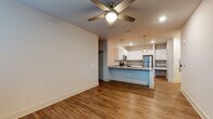 This 2-bedroom, 2-bathroom residence offers a thoughtfully designed single-story layout with modern finishes throughout. The open-concept living and kitchen area serves as the heart of the home, featuring warm wood-look flooring, recessed lighting, and a ceiling fan. A welcoming entryway with natural light leads into the spacious living area.

The kitchen is a standout feature, outfitted with crisp white shaker cabinetry, granite countertops, a peninsula with seating, stainless steel appliances including a range, microwave, and refrigerator, and stylish pendant lighting. Ample cabinet and counter space make this kitchen both functional and visually appealing.

Both bedrooms are generously sized with plush carpeting and windows providing natural light. The primary bathroom impresses with large-format marble-look tile flooring, a granite-topped white vanity, and a glass-enclosed walk-in shower. The second bathroom features wood-look flooring, a granite vanity, and a tiled tub-shower combination. A hallway with utility access connects the main living areas to the private spaces, completing this clean, move-in ready residence.