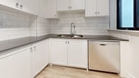 Located at 300 Antibes Dr in Toronto's North York neighbourhood, this well-appointed 3-bedroom, 2-bathroom unit offers a clean, modern aesthetic throughout its thoughtfully laid-out single floor. Light hardwood flooring runs continuously through the living areas, bedrooms, and hallway, creating a cohesive and bright atmosphere.

The combined kitchen and living area forms the heart of the unit. The kitchen is outfitted with crisp white cabinetry, a classic subway tile backsplash, dark countertops, and stainless steel appliances including a refrigerator and dishwasher. A peninsula provides additional prep space and visual separation from the living area, which opens onto a private balcony through a large sliding glass door, bringing in natural light and elevated views of the surrounding cityscape.

Each of the three bedrooms is generously sized, featuring large floor-to-ceiling windows that frame sweeping city views. The primary bedroom includes mirrored sliding closet doors that enhance the sense of space. A dedicated closet adjacent to one of the bathrooms provides additional storage.

The two bathrooms are finished with white subway tile surround, chrome fixtures, and a clean, contemporary vanity. A separate closet space adds to the unit's practical storage solutions. The hallway connects all rooms efficiently, completing this well-organized and modern residential space.
