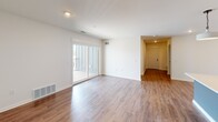 This contemporary 1070 square foot apartment in Caledonia, MI offers a blend of comfort and functionality. The space features two bedrooms, including a primary bedroom of 150 square feet, and two full bathrooms. The open-concept design seamlessly integrates the kitchen and living room, creating a spacious feel.

The kitchen boasts modern appliances, including a built-in microwave, and sleek cabinetry with contrasting hardware. A large island with a sink serves as both a prep area and casual dining space. The living area is illuminated by natural light from sliding glass doors leading to an outdoor space.

Both bedrooms feature plush carpeting and closets with wire shelving systems for optimal organization. The bathrooms are well-appointed, with one showcasing a large walk-in shower with glass doors and warm wood-look flooring.

The apartment includes a dedicated laundry room with full-size washer and dryer, adding convenience to daily life. Throughout the space, you'll find a cohesive design with neutral walls, recessed lighting, and a mix of carpeting and wood-look flooring. The overall ambiance is one of modern simplicity and practicality, perfect for comfortable living.