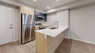 Located at 4019 Hiddenluck St in North Cowichan, BC, this thoughtfully designed one-bedroom, one-bathroom unit offers a clean, modern aesthetic with an efficient and well-organized floor plan. The open-concept living area seamlessly combines the kitchen, dining, and living spaces, all finished with warm-toned luxury vinyl plank flooring that runs throughout the unit. The kitchen is well-appointed with light wood cabinetry, crisp white quartz countertops, a double stainless steel undermount sink with a sleek pull-down faucet, and stainless steel appliances including a dishwasher, range, and built-in microwave with dark upper cabinetry adding a stylish contrast. The living area is bright and airy, with windows and a glass door providing direct access to a private balcony with neighbourhood views. A wall-mounted mini-split heating and cooling unit ensures year-round comfort. The bedroom is a comfortable, well-lit retreat with a large window, baseboard heating, and ample closet space provided by two dedicated closets. The bathroom features a full soaker tub with shower, a light wood vanity with white countertop, and tile-effect flooring. In-unit laundry adds everyday convenience. The unit's neutral grey palette and modern finishes create a clean, contemporary ambiance throughout.