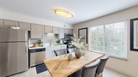 Located at 904 Atlantic Ave in Hoffman Estates, IL, this single-floor residence offers 2 bedrooms and 2 bathrooms thoughtfully arranged for comfortable living. The open-concept kitchen, dining, and living area forms the heart of the home. The kitchen is outfitted with gray-toned cabinetry, a mosaic tile backsplash, stainless steel appliances — including a refrigerator, dishwasher, microwave, and range — and light countertops, all complemented by light wood-style flooring. A sliding glass door in the dining area fills the space with natural light and provides outdoor views, while a stylish oval flush-mount ceiling fixture adds a modern touch. The dining area flows naturally into a welcoming living room featuring soft carpeting, a tiled fireplace, and a multi-window wall that brings in abundant natural light. The spacious primary bedroom offers plush carpeting, a large closet, and a bright window overlooking greenery, creating a calm and restful retreat. The second bedroom is equally comfortable and well-lit. Both bathrooms are clean and functional, with one featuring a tub-shower combination and light vanity cabinetry. A hallway and dedicated closet round out the layout, providing practical storage solutions throughout this well-designed residence.