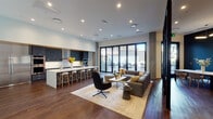 This sophisticated single-floor space is designed with a seamless open-plan layout that integrates a fully equipped kitchen, a casual lounge area, and a dedicated meeting room. The kitchen is a standout feature, boasting dark, flat-front cabinetry, a generous white quartz island with bar seating, stainless steel appliances including a full-size refrigerator and double wall ovens, a built-in cooktop, and a range hood — all set against white tile backsplash and rich hardwood flooring. The adjoining lounge area is anchored by a large sectional sofa, an accent chair, and a coffee table, all bathed in natural light pouring in through expansive floor-to-ceiling glass doors that open directly to a furnished outdoor terrace. Exposed concrete columns add an industrial character that contrasts elegantly with the warm wood tones and neutral furnishings. A separate meeting room features deep, dark-painted walls, a long white conference table surrounded by contemporary chairs, and a striking geometric pendant light fixture overhead. Colorful glass partitions and display shelving add artistic flair, while recessed lighting throughout ensures a warm, well-lit ambiance. The overall design strikes a balance between functional and refined, making it well-suited for both communal gatherings and focused work.
