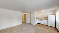 Located at 401 Ratcliff Dr SE in Salem, Oregon, this two-bedroom, one-bathroom unit offers a practical and efficient single-floor layout. The interior features a combination of wood-look flooring in the main living and kitchen areas and plush carpeting throughout the bedrooms, providing a comfortable feel underfoot.

The kitchen is well-equipped with white cabinetry, ample counter space, a stainless sink, and a full suite of white appliances including an electric range, dishwasher, and refrigerator. A window above the kitchen area allows natural light to brighten the space.

Both bedrooms are carpeted and feature textured ceilings, baseboard heating, and windows fitted with blinds that bring in natural light while maintaining privacy. Each bedroom includes a closet with bi-fold doors, offering practical storage. The primary bedroom provides a comfortable and functional retreat.

The bathroom is clean and straightforward, featuring wood-look flooring, a vanity with storage, a toilet, and a full bathtub with shower. Neutral, light-toned walls throughout the unit create a bright and cohesive atmosphere. Overall, this unit offers a functional layout well-suited for everyday living in a residential Salem neighborhood.
