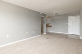 Located at 207 Galley Rd in Colorado Springs, CO 80909, this single-floor unit offers a straightforward and functional layout across several well-defined living spaces. The living area is generously sized, featuring neutral-toned carpet flooring, soft gray walls, a textured ceiling, and a baseboard heating system. A window allows natural light to filter in, creating a bright and open atmosphere. The space flows naturally into a kitchen area defined by tile flooring, white cabinetry with ample storage both above and below the counter, tile countertops with a wood trim accent, a stainless steel double sink, and white appliances including a refrigerator and an electric range. A pass-through counter connects the kitchen to the main living area, enhancing the open feel. The unit includes multiple carpeted bedrooms, each finished with the same neutral gray palette, textured ceilings, white baseboards, and baseboard heaters, providing consistent and comfortable living spaces. The bathroom features tile flooring, a white vanity with under-sink storage, a wood-toned countertop, a lighted vanity mirror, and standard fixtures. Throughout the unit, the consistent use of neutral tones and functional finishes creates a clean, move-in-ready environment well suited for everyday living in Colorado Springs.